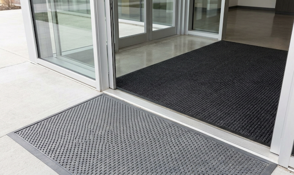 a commercial entrance mat place in the doorway of a commercial building